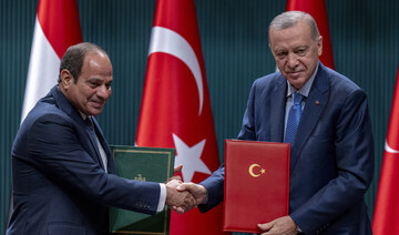 Turkish President Recep Tayyip Erdogan shakes hands with Egyptian President Abdel Fattah El-Sissi.