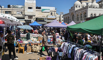 Palestinians shop at a market in Ramallah, in the occupied West Bank on April 19, 2024. (AFP)