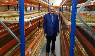 The governor of the Central Bank Riad Salameh stands next to stacks of gold bars on shelves in Beirut. (AFP)